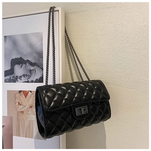 Detail of black quilted leather shoulder bag featuring silver metal chain and twist-lock