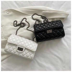 Close-up of quilted cross-body bags with diamond pattern and metal chain straps
