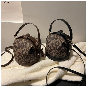 Detailed view of leopard print mini barrel bags with metal buckle and detachable straps