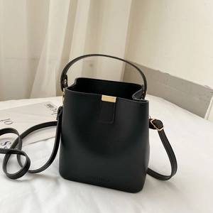 Minimalist black faux leather bucket bag with gold hardware and fashion lettering