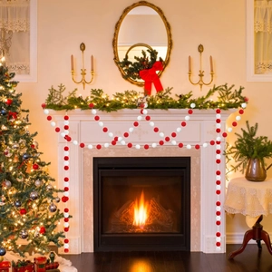 Detail of red and white felt ball garland hanging on a fireplace for festive decor