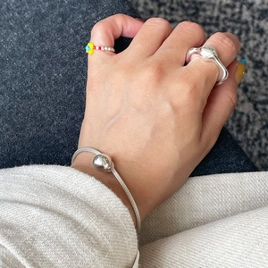Minimalist silver irregular molten ring and polished bead bracelet worn on hand