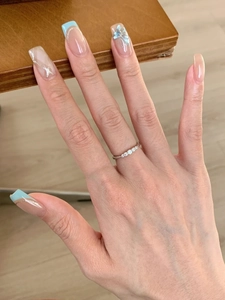 Close-up of minimalist silver band ring with five sparkling round diamonds on finger