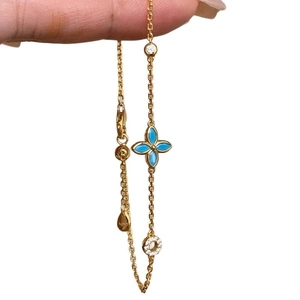 Minimalist gold-plated silver bracelet with blue four-petal flower and sparkling charms