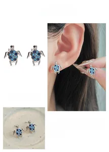Detailed view of silver turtle studs with micro-set blue crystals and model display