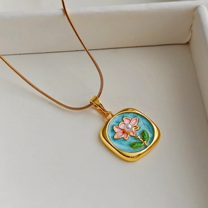 Vintage gold necklace featuring a blue enamel floral pendant with a centered pearl