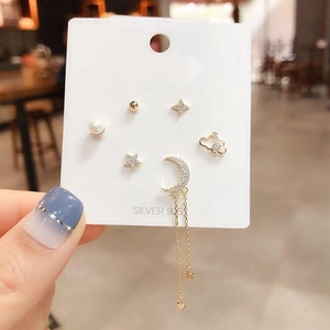 Macro shot of silver 925 star moon cloud stud earring set with long tassel details