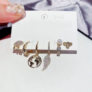 Detail shot of 6-piece gold earring set with elephant, bee, and pearl elements