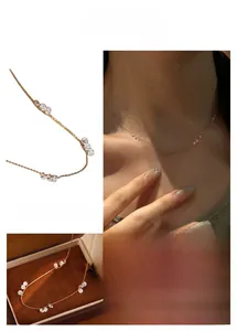 Détail d'un collier doré élégant avec perles de zircon rondes sur une chaîne fine