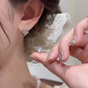 Close-up of elegant hollow flower earrings with sparkling pavé crystals on a model