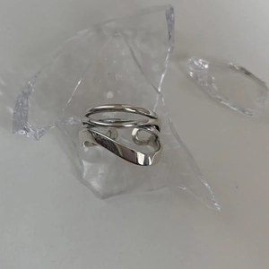 Anello aperto multistrato argento con linee intrecciate e design moderno