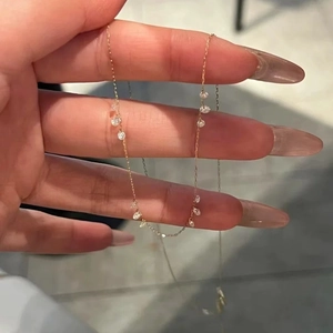 Vue détaillée d'un collier en chaîne dorée avec des pierres de zircon de coupe ronde