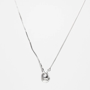 Close-up of a silver geometric pendant on a box chain with a mirror finish and organic design