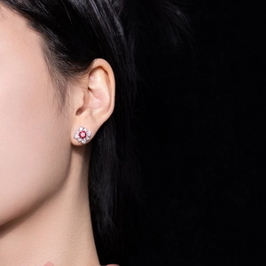 Exquisite red zircon flower stud earrings with shimmering stones shown on a model