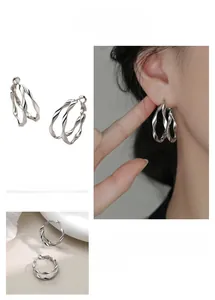 Macro shot of silver double-layered twisted hoop earrings with a secure clasp design
