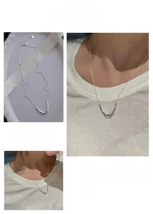 Detail of silver U-shaped horn pendant necklace with minimalist hammered metal texture