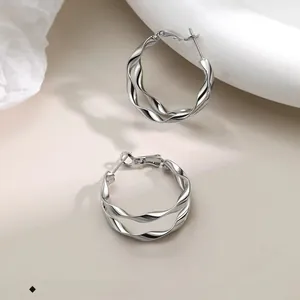 Macro shot of silver twisted hoop earrings showcasing double-layer spiral texture details
