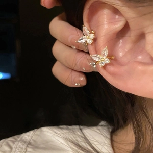 Golden butterfly ear cuff with micro-pave zircons worn on a female ear model