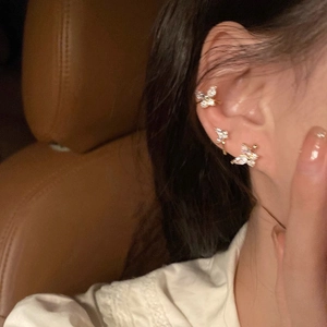 Detail of elegant butterfly ear studs with micro-set zircons worn on model's ear
