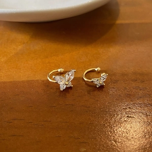 Macro shot of gold butterfly ear cuffs featuring shimmering marquise zircon stones