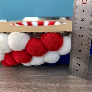 Détail montrant l'épaisseur de 7 cm de la couronne de pompons rouge blanc bleu de l'Indépendance