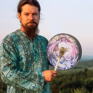Detail of Shamanic drum with purple dragon totem and fur-trimmed mallet in nature