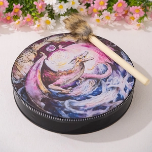 Detail of shamanic drum with dragon artwork and faux fur mallet on white background