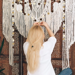 Bohemian white macrame wall hanging with feather detail and colorful felt pom pom garland