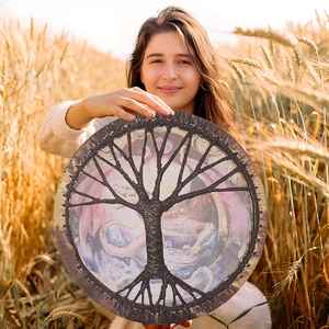 Samanic Tree of Life drum with purple mystical design held in a golden wheat field