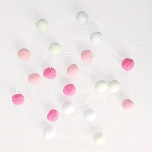 Détail de la guirlande de pompons colorés en rose blanc et vert pour décoration