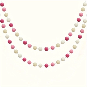 Détail d'une guirlande de 2 mètres avec pompons roses et blancs pour décoration de fête