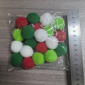 Macro view of 2m Christmas wool felt balls in red and green with a ruler for size