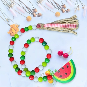 Close-up of watermelon wood bead garland with jute tassel and farmhouse pendant