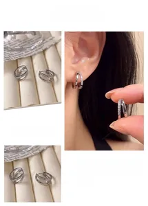 Detail of silver double hoop earrings with cubic zirconia on a velvet display tray