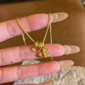 Elegante collana dorata con ciondoli a cuore, stella ottagonale e luna a rilievo
