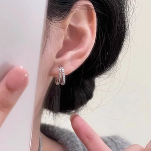 Double layered silver hoop earrings with sparkling cubic zirconia on a female model