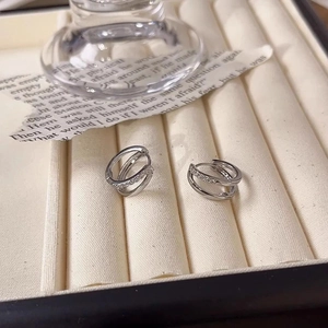 Close-up of silver double-loop earrings with pavé cubic zirconia on a velvet tray