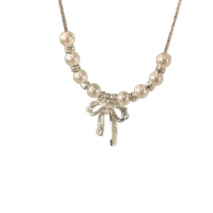 Collier de perles vintage français avec pendentif nœud argenté pour femme sur blanc