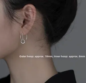 Detail shot of silver geometric C-shape earrings featuring a micro-pave zircon small hoop