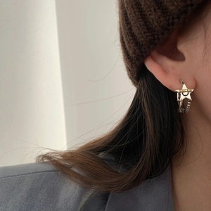 Chic silver star hoop earrings featuring Lucky text and smiley face worn by a model