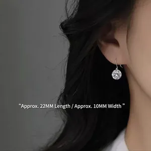 Boucles d'oreilles argentées avec zircone ronde, taille 22mm x 10mm, sur un mannequin femme