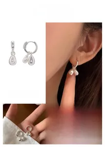 Detail of silver drop pearl earrings featuring a French minimalist hoop design for women