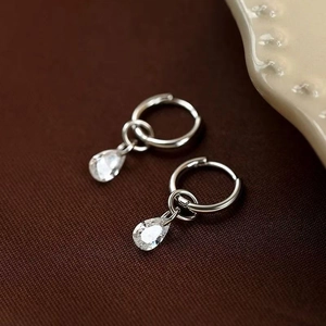 Créoles minimalistes en argent avec pendentifs en zircon poire sur tissu sombre