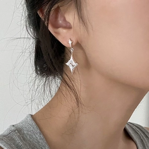 Irregular starburst zircon stud earrings in silver finish worn by a model in close-up