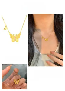 Vue détaillée du pendentif papillon mat avec pierre rose et zircon sur chaîne dorée