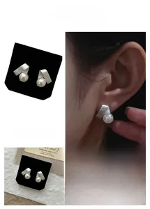 Détail de boucles d'oreilles perles satinées argentées avec finition métal brossé