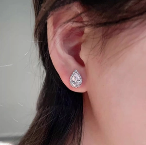 Classic silver-tone pear-cut halo stud earrings with sparkling cubic zirconia on model