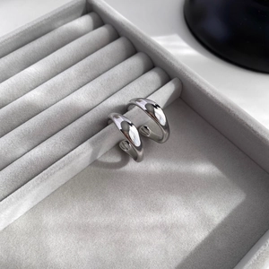 Polished silver geometric hoop earrings displayed in a luxury grey velvet jewelry box