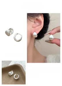 Detailed view of silver teardrop earrings with a brushed metal matte finish and minimalist style