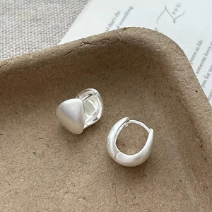 Macro view of matte silver teardrop earrings with brushed metal finish and clasp detail